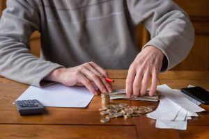 Close up man with calculator counting, making notes at home, han